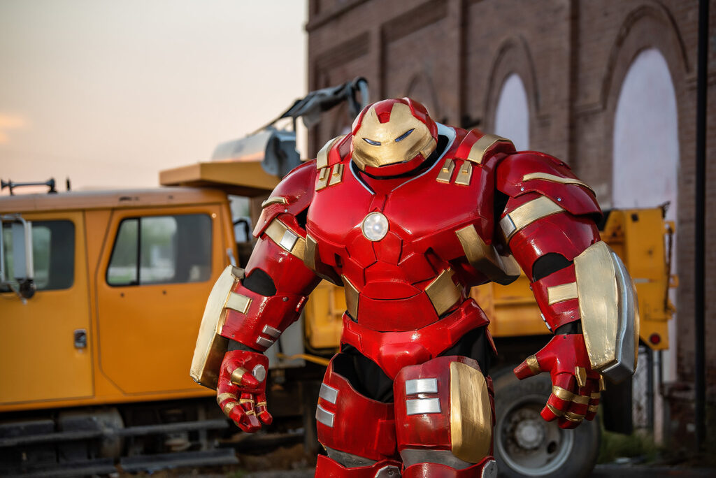 The hulkbuster standing in an alley outside a brick building with construction equipment behind him